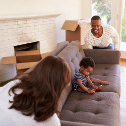 Couple moves a sofa into their new house.