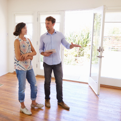 Male Realtor Showing Female Client Around House